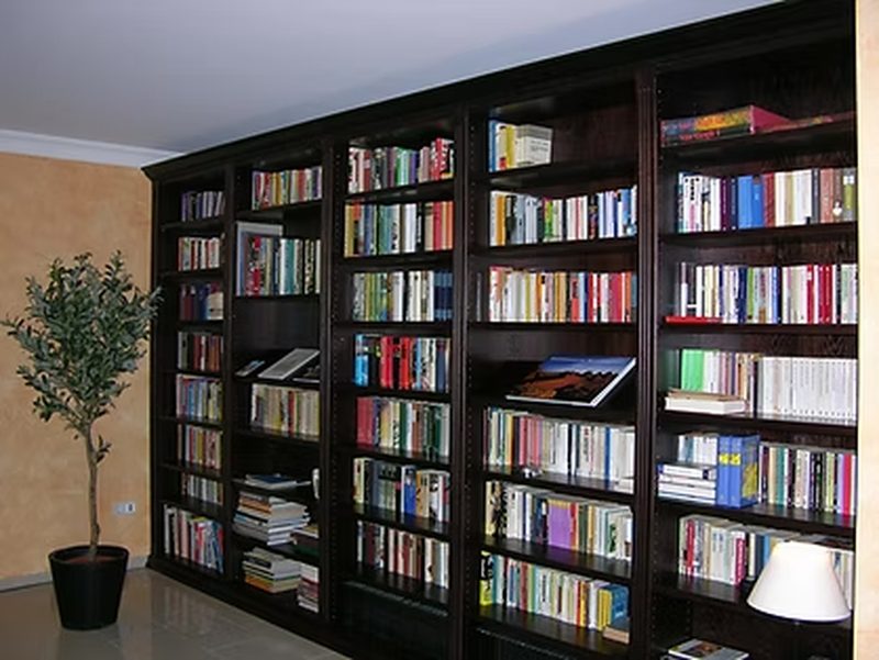 Raumhohe Bücherwand in Eiche, dunkel gebeizt, über eine ganze Wand.