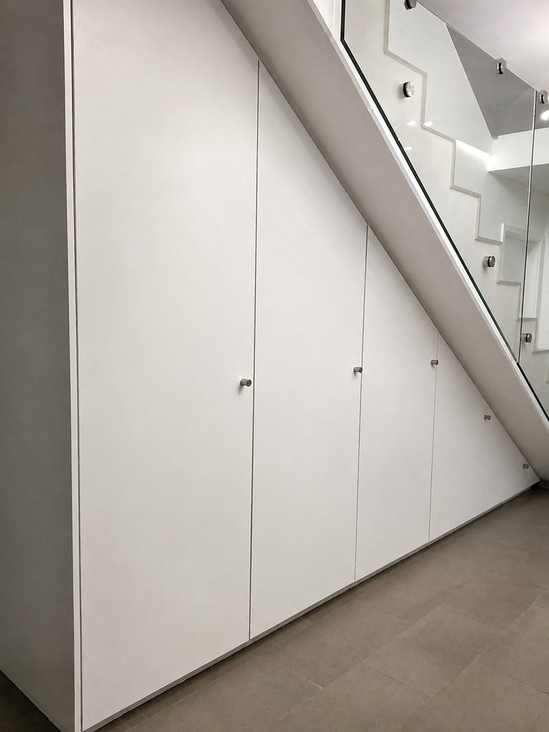 Schrank unter der Kellertreppe. Hinter den Türen ausziehbare Tablare.